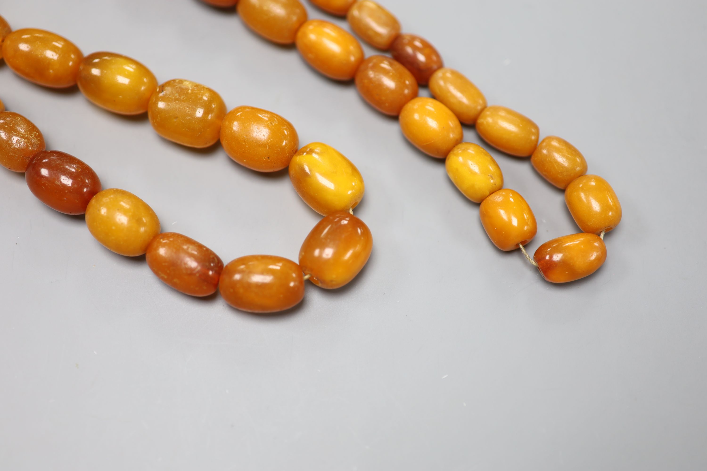 A single strand, graduated oval amber bead necklace, 86cm, gross 104 grams